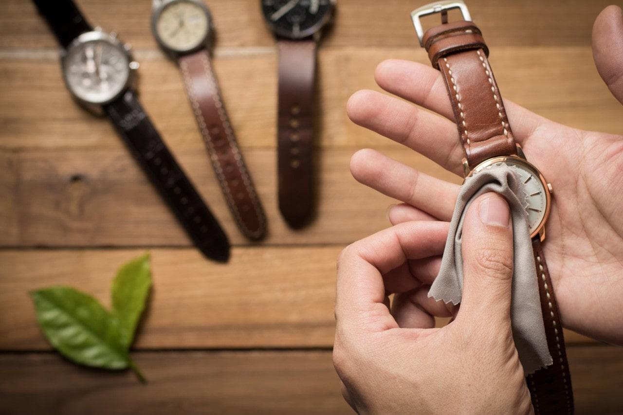 A person wiping their watches off at home with a soft cloth
