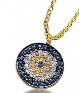 Reminiscent of an evil eye motif, gems create circles within circles on this medallion; blue sapphires, diamonds, yellow diamonds, and then a single sapphire bull’s eye