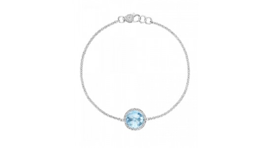 a white gold chain bracelet featuring a round cut topaz