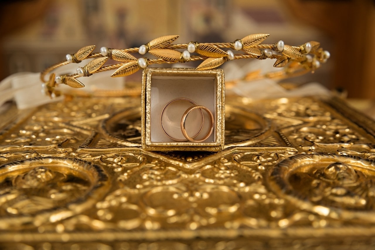 ornate and lavish gold wrapping boxes containing two wedding bands