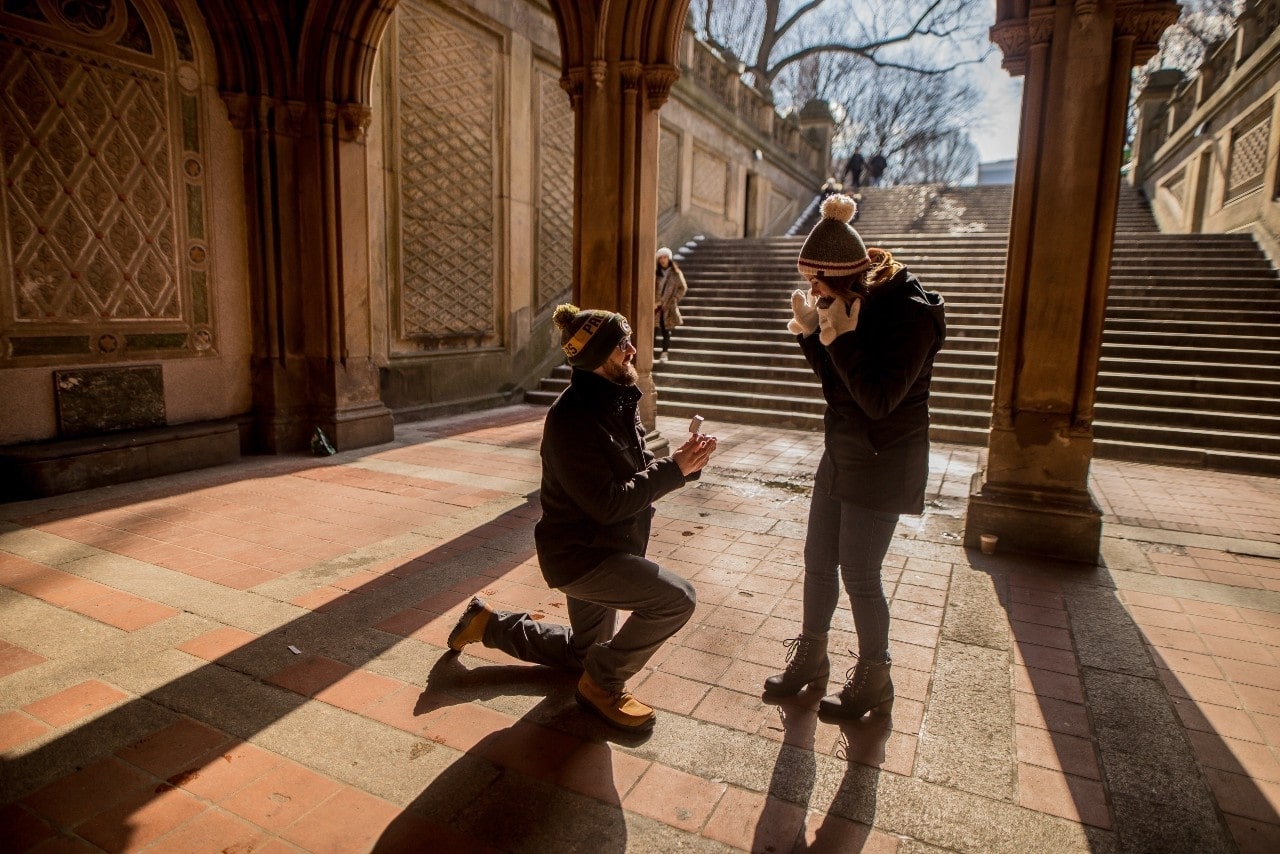 a man presenting a ring to a woman outside