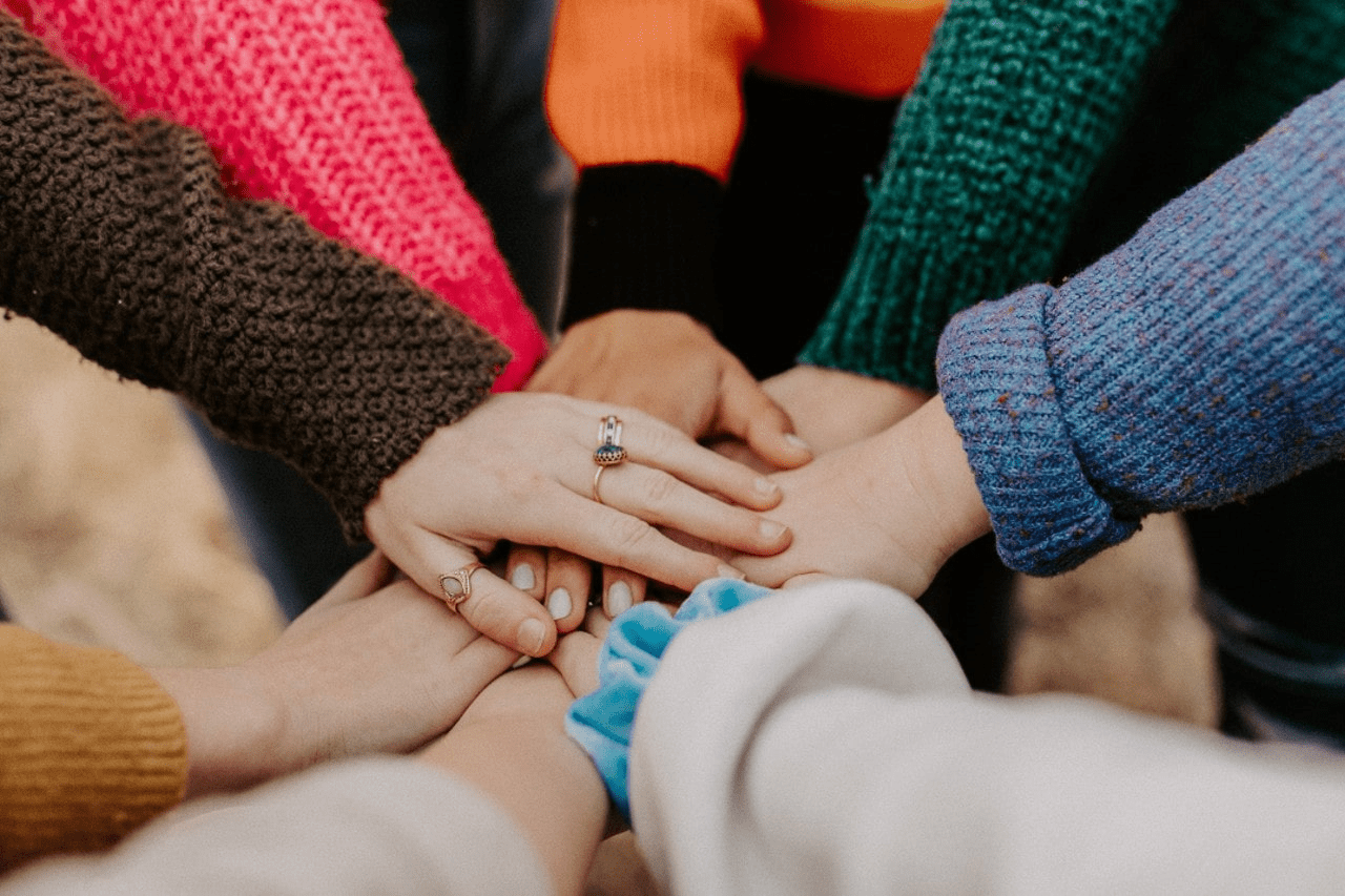A group of friends joining hands and wearing jewelry