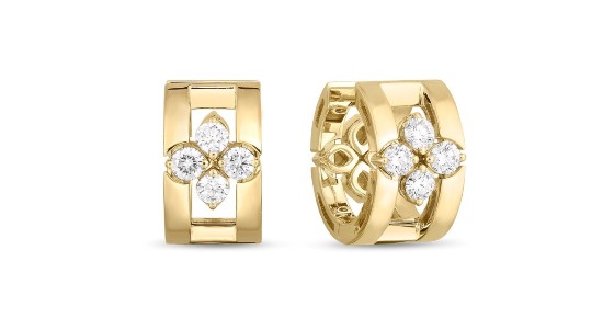 a pair of yellow gold huggies earrings featuring diamonds set in a floral shape