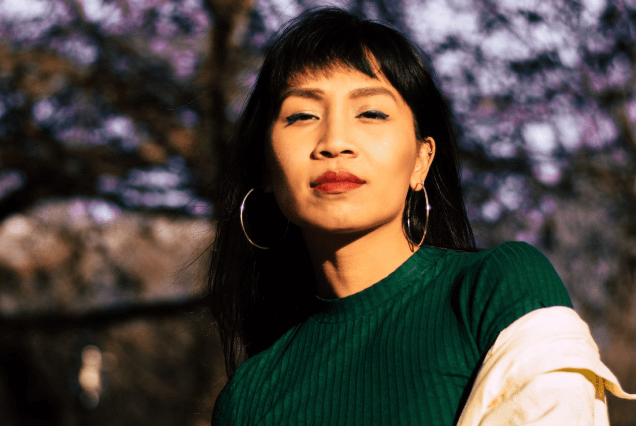 lady wearing layered clothing and hoop earrings