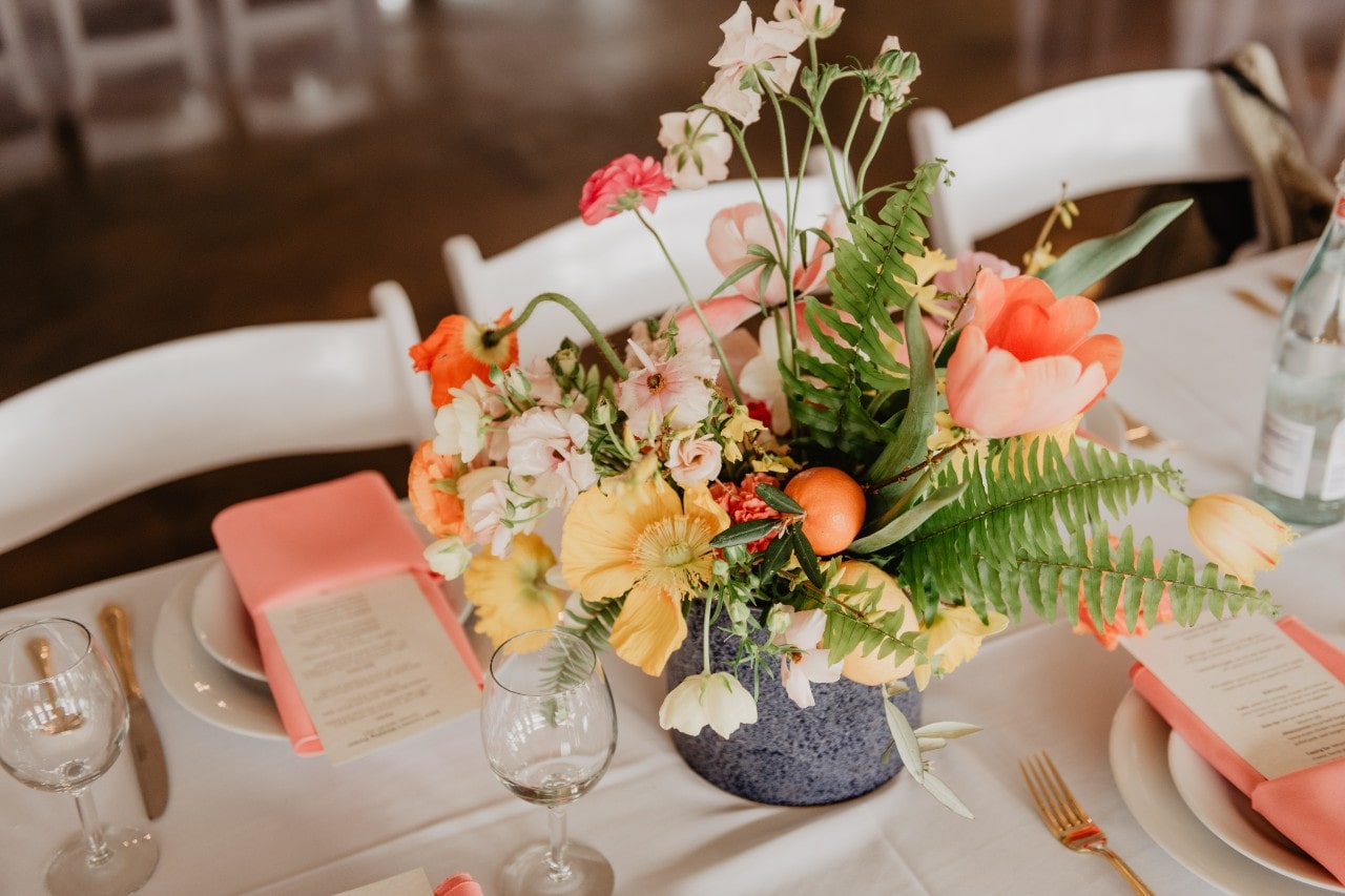a table set at a wedding ceremony with a floral centerpiece