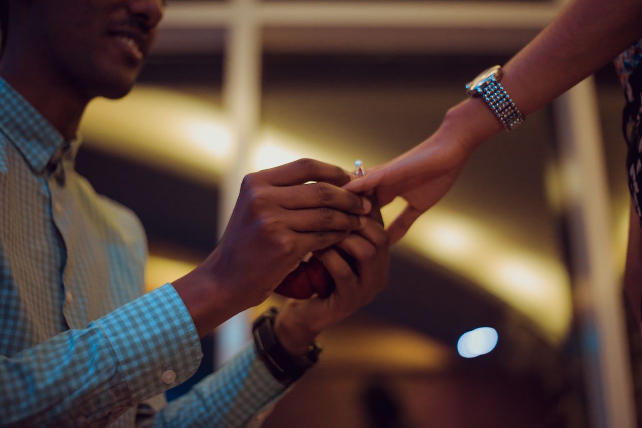 a man gets down on one knee and slips an engagement ring on his darling’s finger during an evening date.