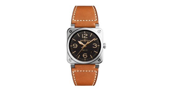a white gold watch with a black dial and tan indices and a brown leather strap