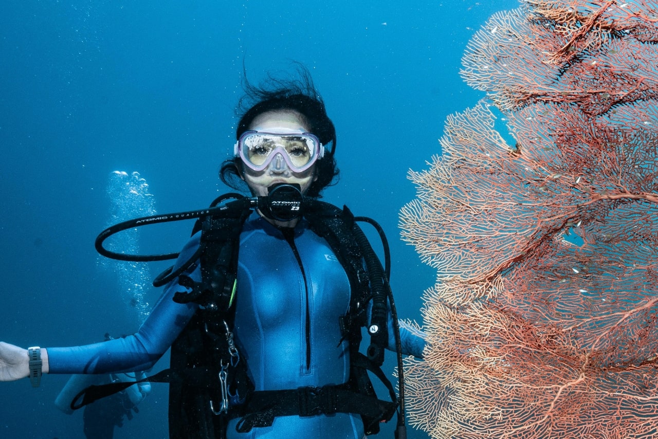 a woman scuba diving and wearing a watch with a rubber strap