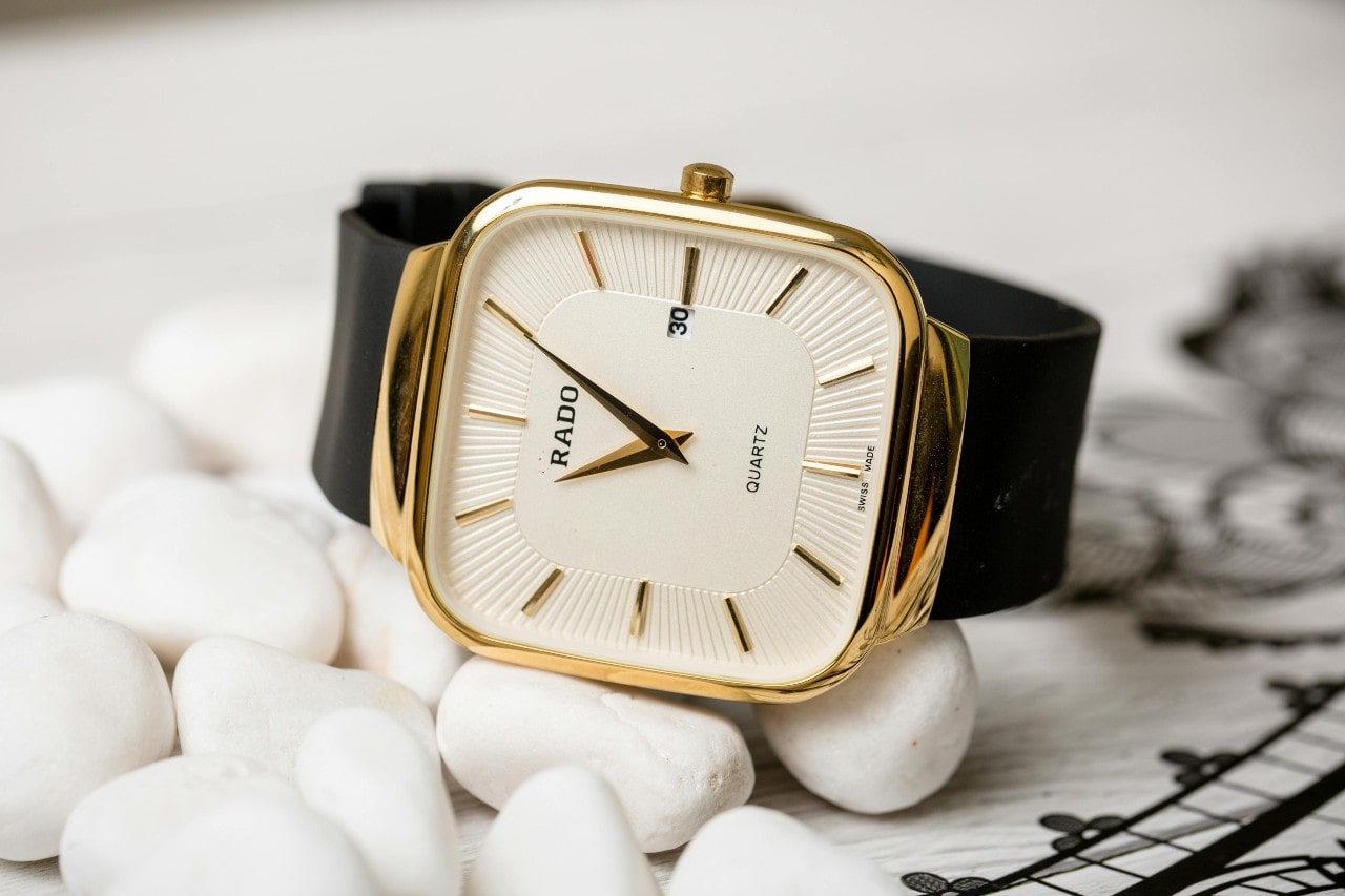 A close-up of a wristwatch with a square case.