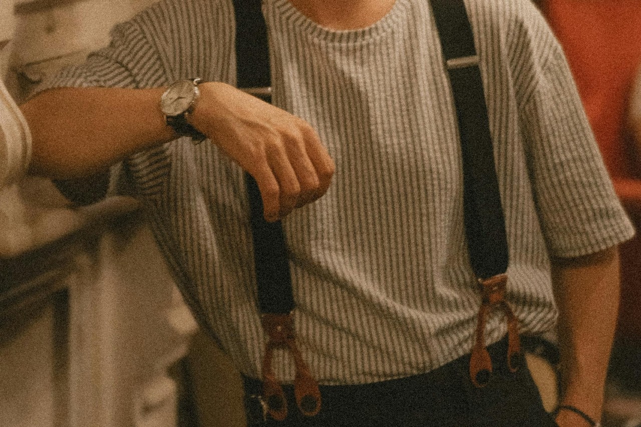 A close-up of a person wearing a watch with a round case.