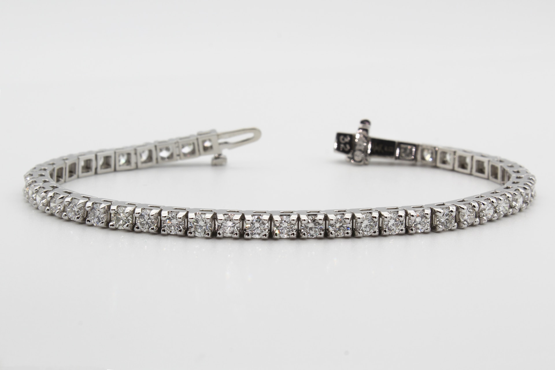 a platinum diamond tennis bracelet against a white background