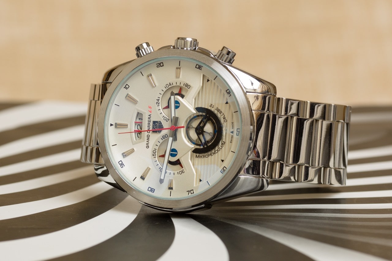 a TAG Heuer Grand Carrera watch on a striped background