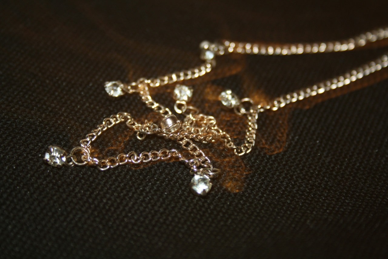 A close-up of a simple yet elegant yellow gold necklace. A close-up of a simple yet elegant yellow gold necklace.