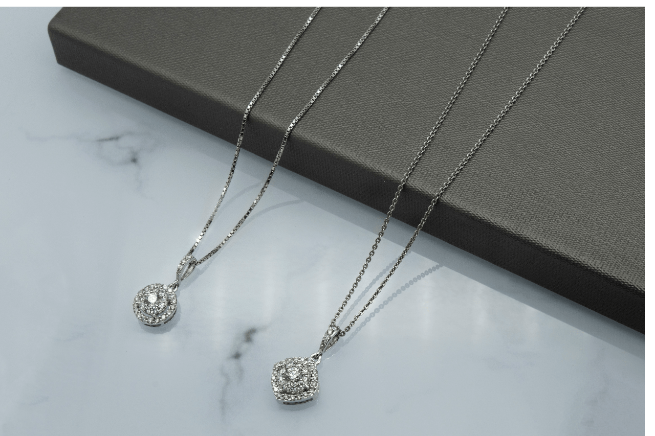 A close-up of two stunning white gold diamond pendant necklaces. A close-up of two stunning white gold diamond pendant necklaces.