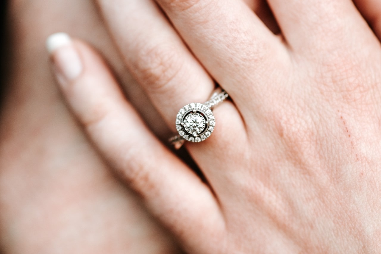 a lady’s hand wearing a platinum engagement ring