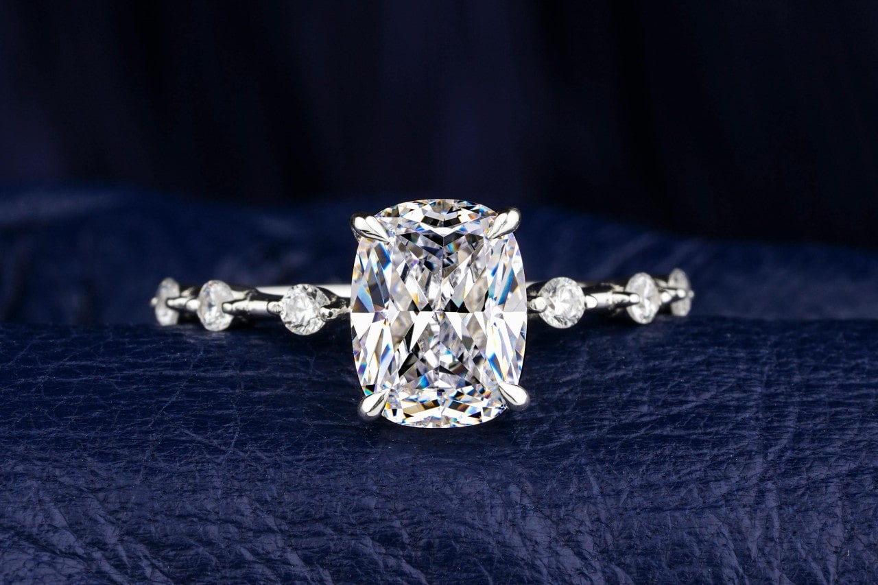 A close-up image of a simple engagement ring with a large center stone and side stones A close-up image of a simple engagement ring with a large center stone and side stones